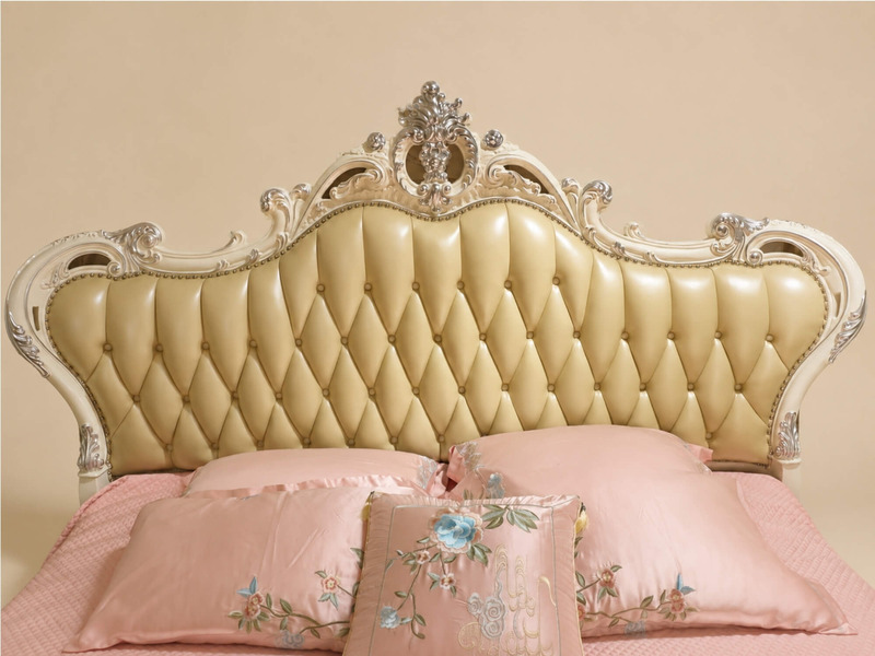 Cận cảnh phần đầu giường của MONARCHIA 1m8, tập trung vào chi tiết bọc da màu kem/vàng nhạt với các múi rút khuy sâu, tạo…