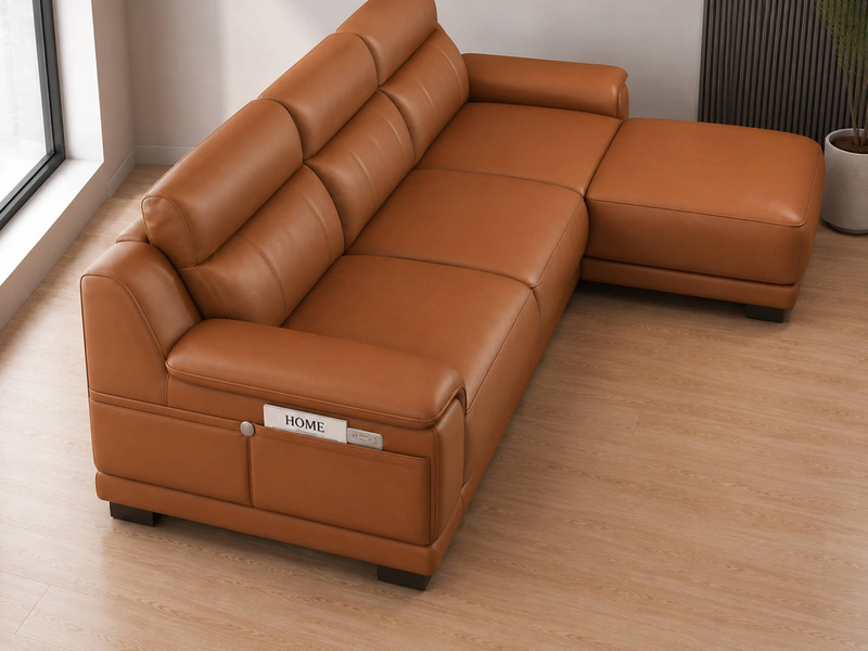 Sofa VENTO góc L màu nâu caramel, chụp từ trên cao xuống, cho thấy toàn bộ chiều sâu và cấu trúc của sofa. Các múi đệm phồ…
