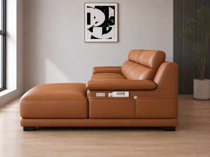 Sofa VENTO góc L màu nâu caramel, chụp cận cảnh phần góc L và tay vịn bên phải. Tay vịn có tích hợp ngăn chứa đồ và cổng s…