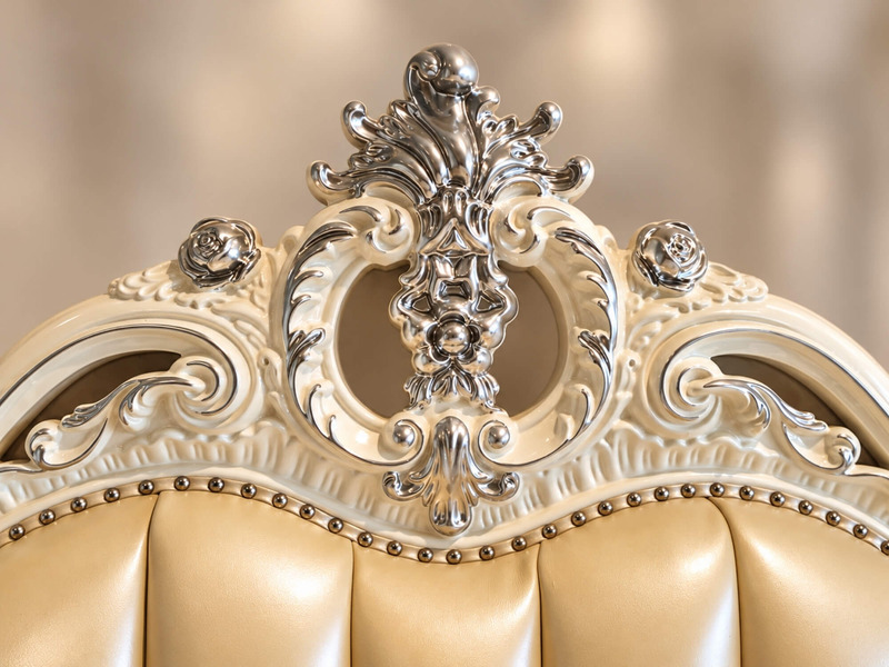 Cận cảnh phần đỉnh đầu giường của chiếc giường ROCOCO, với họa tiết chạm khắc hoa văn đối xứng phức tạp, mạ vàng nổi bật…