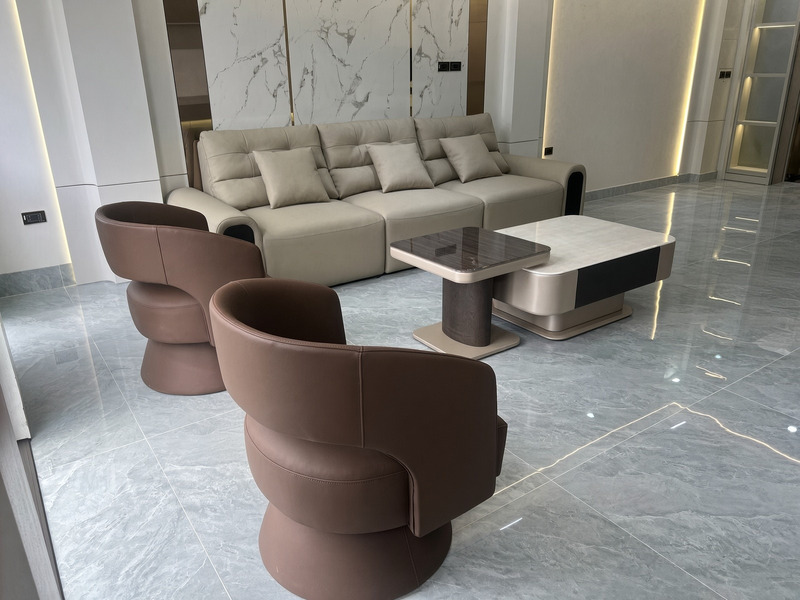 Ghế bành xoay dáng tròn bọc da nâu cùng sofa văng kem và bàn trà mặt tại nhà khách hàng – Nội Thất Gia Khánh