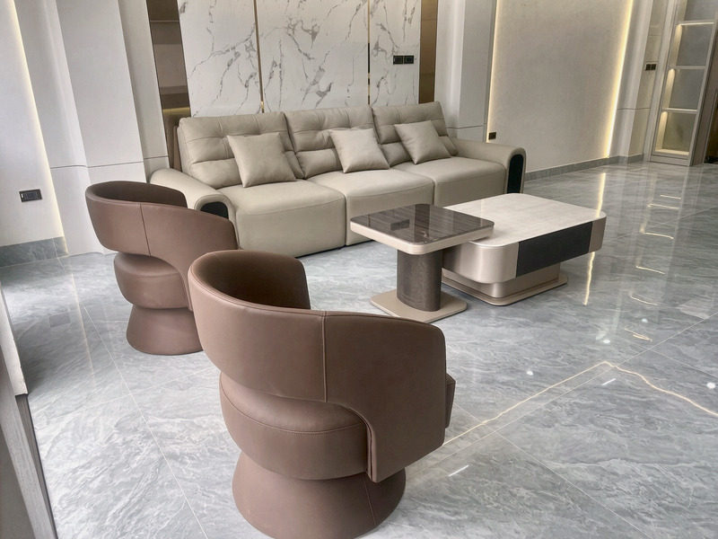 Ghế bành xoay dáng tròn bọc da nâu cùng sofa văng kem và bàn trà mặt tại nhà khách hàng – Nội Thất Gia Khánh