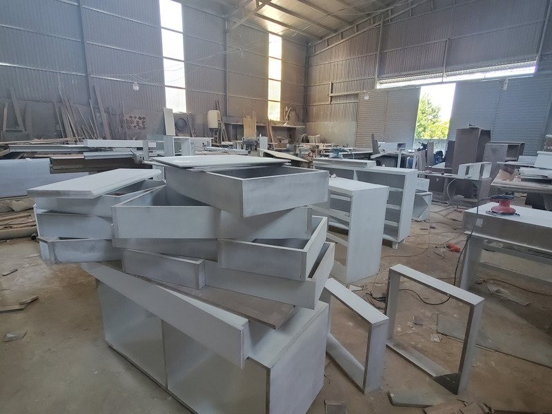 Ngăn kéo và thân tủ đã phủ sơn lót xếp chờ lắp trong nhà xưởng Nội Thất Gia Khánh